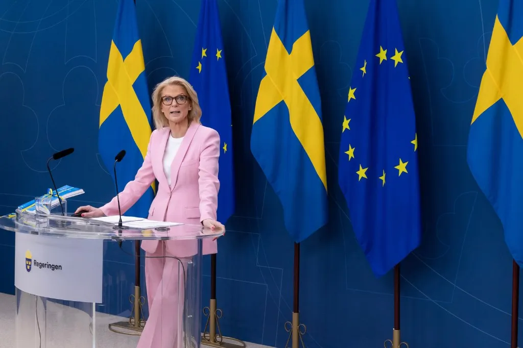 Finansminister Elisabeth Svantesson presenterar vårbudgeten vid en pressträff iklädd en rosa kostym.