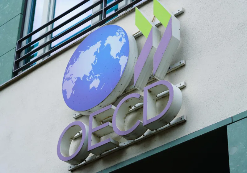 OECDs globe logo in color on a beige building wall