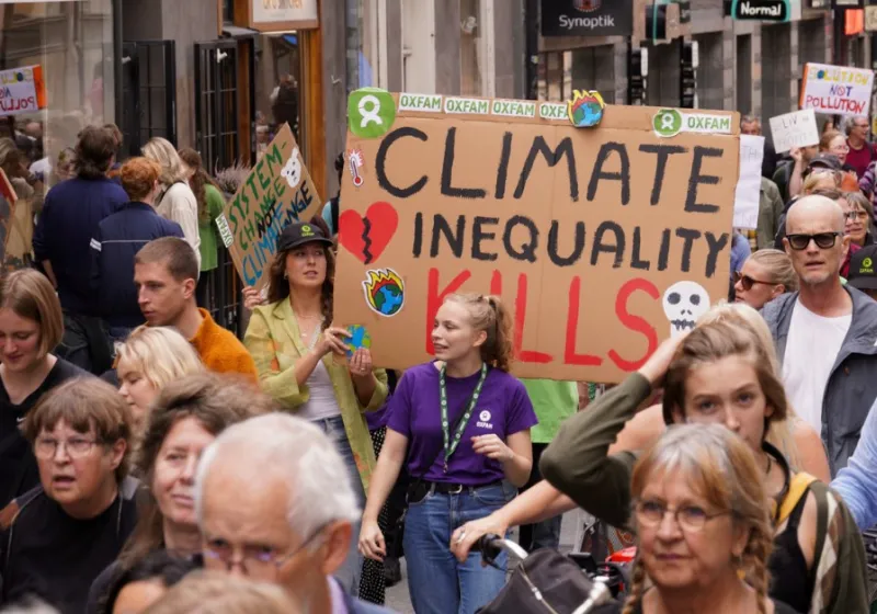 Demonstration på Götgatan i Stockholm. Människor med skyltar. En har texten climate inequality kills.. Text