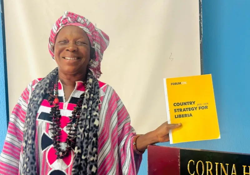 Woman holding the Liberia country strategy and smiling
