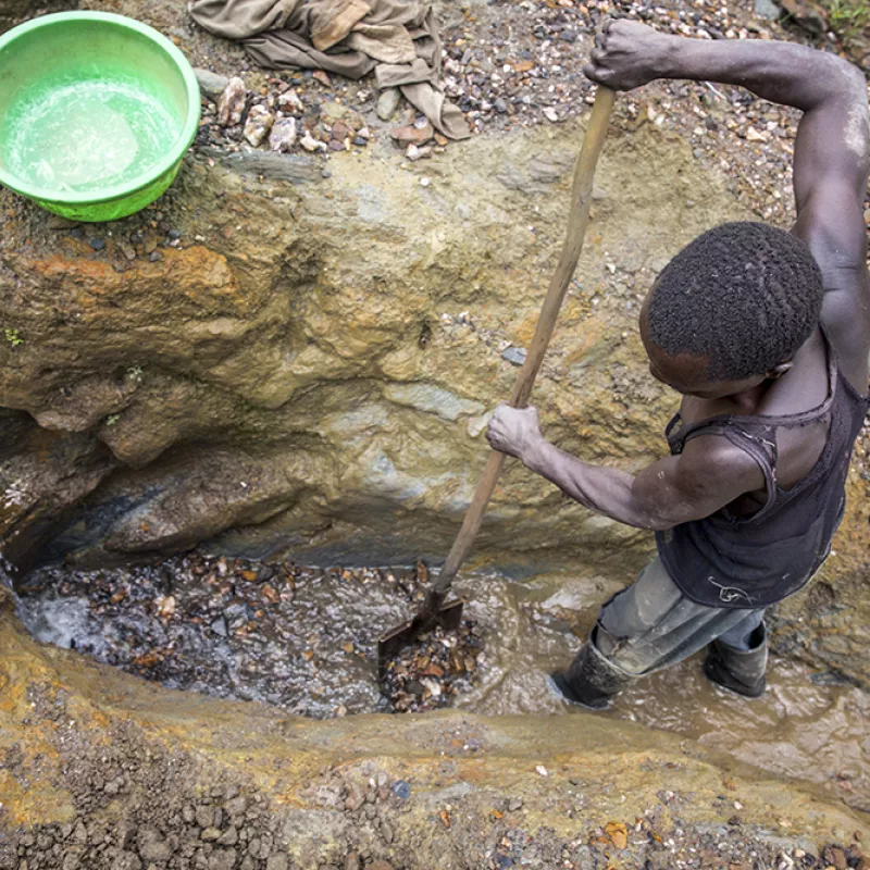 A man is digging for gold in a mine.